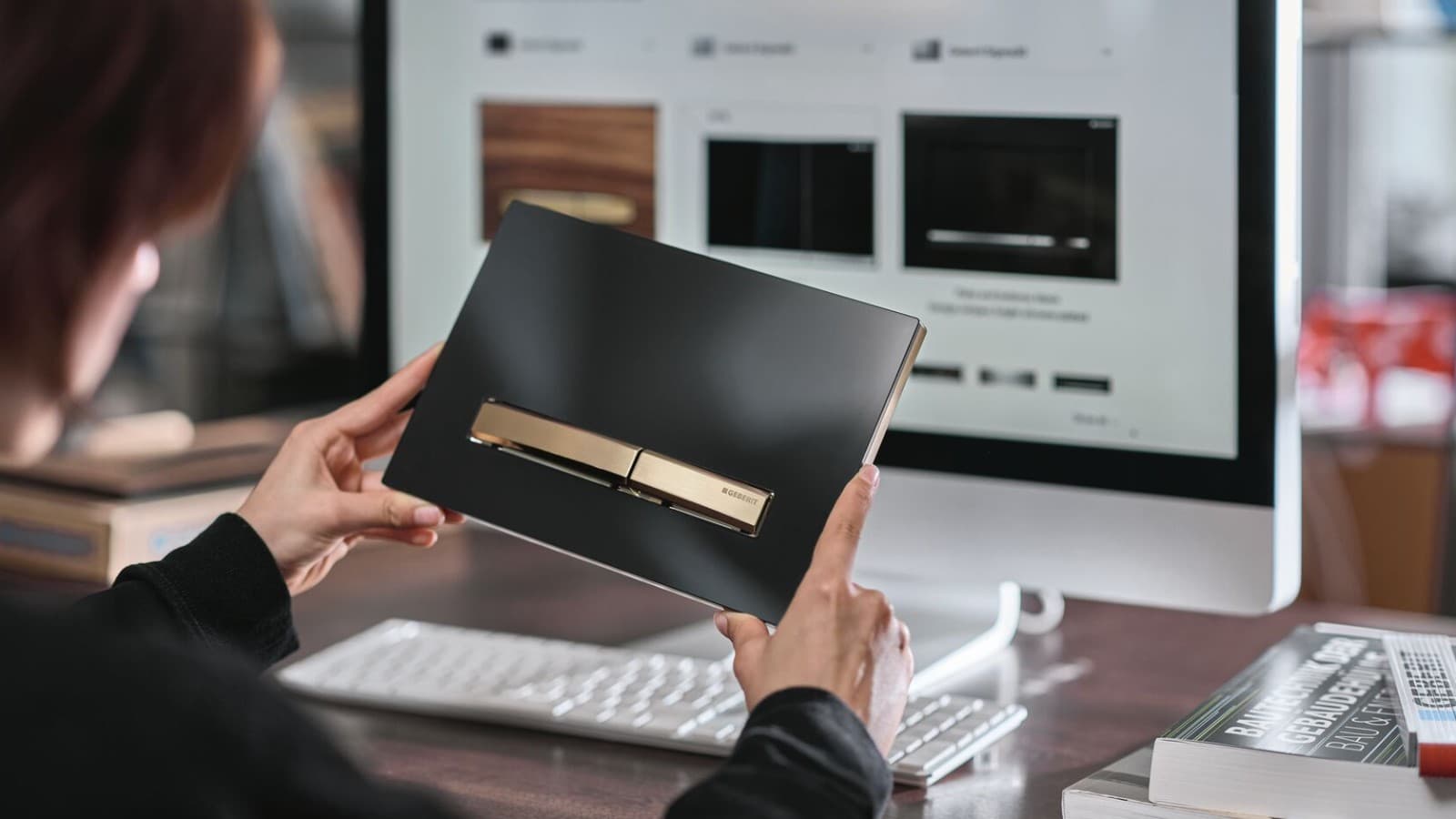 Mulher com placa de comando de descarga Geberit Sigma50 com tecla de comando em efeito rosa dourado Mulher com placa de comando de descarga Geberit Sigma50 com tecla de comando em efeito rosa dourado