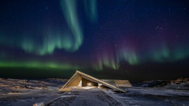 O Icefjord Centre sob a espetacular aurora boreal da noite polar da Groenlândia (© Adam Mørk)